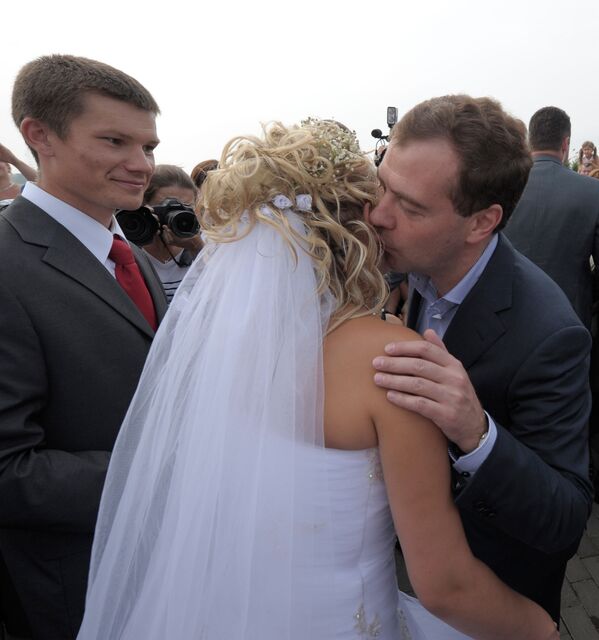 الرئيس الروسي دميتري ميدفيديف (يمين) خلال نزهته ضفة نهر بيرا، هنأ أحد المتزوجين حديثًا على زواجهما بقبلة للعروس، بيروبيدجان الروسية 2 فبراير 2010 - سبوتنيك عربي