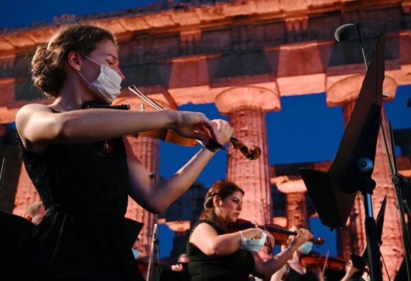 الموسيقيون قبيل حفل الأوركسترا Luigi Cherubini Youth Orchestra بحضور تسعة موسيقيين من الجالبة السورية في أوروبا،  كجزء من حفل الصداقة الرابع والعشرين، في موقع بايستوم الأثري في جنوب إيطاليا، في 5 يوليو / حزيران 2020 - سبوتنيك عربي