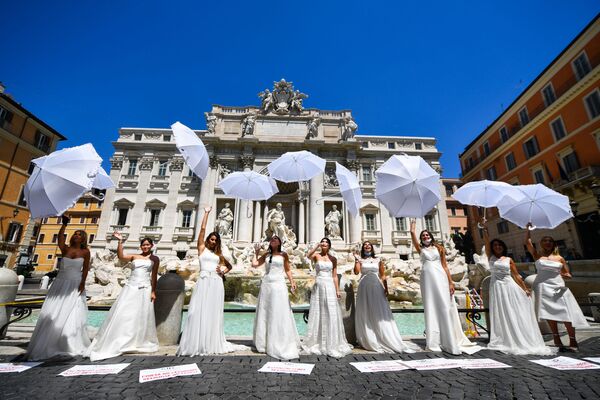 النساء اللواتي تم تأجل حفل زفافهن أو ألغي، نتيجة للقيود التي فرضتها البلاد بسبب تفشي فيروس كورونا، يحتجون أمام نافورة تريفي في روما، إيطاليا 7 يوليو  2020 - سبوتنيك عربي